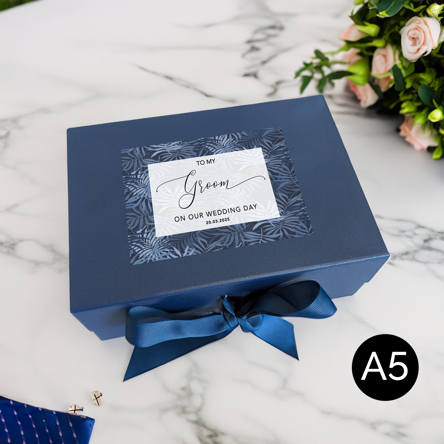 a blue box with a blue ribbon and a flower bouquet